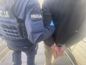 policjant prowadzi zatrzymanego