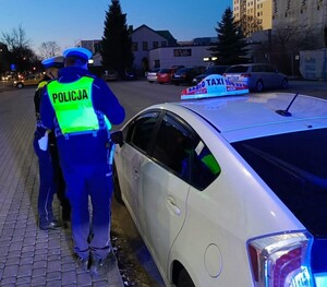 Policjanci kontrolują taksówkę
