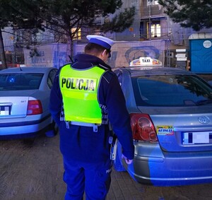 policjant kontroluje taksówki