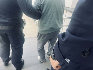 Policjanci prowadzą zatrzymanego