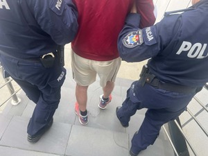 policjanci prowadzą zatrzymanego