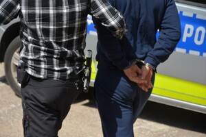 policjant prowadzi zatrzymanego
