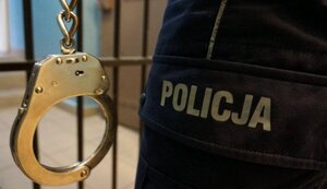 kajdanki i fragment munduru policjanta