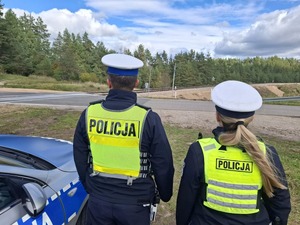 policjanci przy radiowozie sprawdzający teren przyległy do torów kolejowych