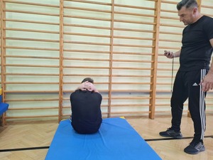 kandydaci na policjantów ćwiczący na hali sportowej