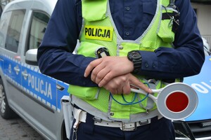 Policjant z tarczą do zatrzymywania w tle radiowóz